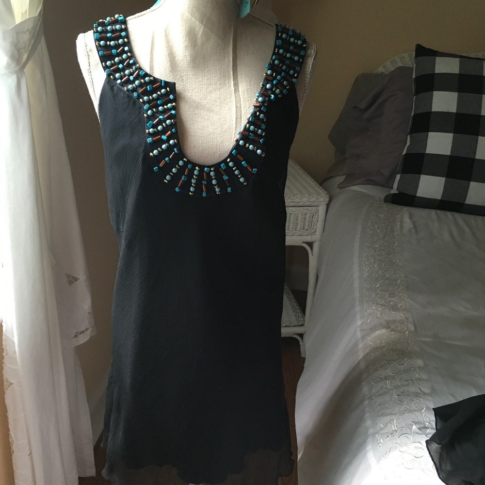 Black poly/silk lining blouse with bead embellished neckline. Rolled hem.